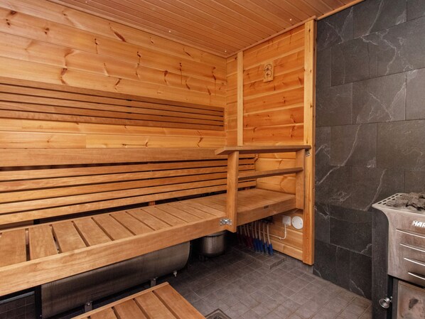 Un sauna con bancos de madera y una pared de piedra.