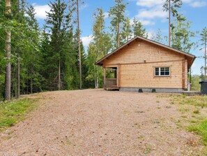 A wooden cabin with a porch, surrounded by a forest. - Kaitaranta by Interhome (Mikkeli)