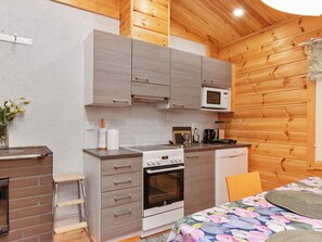 A compact kitchen with a microwave, oven, and a small sink. - Kaitaranta by Interhome (Mikkeli)