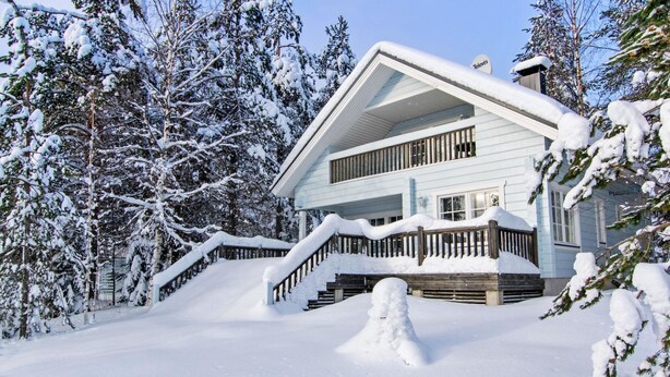 A two-story cabin with a covered porch and a snow-covered landscape. - Lomataivas mökki by Interhome (Hyrynsalmi)