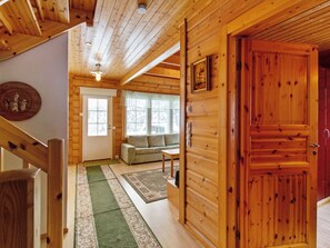 Un intérieur en bois avec un escalier, un canapé et une porte.