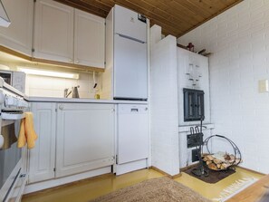 A compact kitchen with white cabinets, a built-in oven, and a refrigerator. - Lomaluola 5a paritalo by Interhome (Hyrynsalmi)