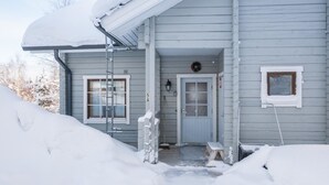 A house with a covered porch, a front door, and a small window. - Lomaluola 5a paritalo by Interhome (Hyrynsalmi)