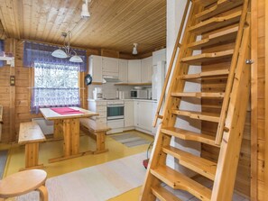 A wooden interior with a kitchen, dining area, and a wooden ladder. - Lomaluola 5a paritalo by Interhome (Hyrynsalmi)