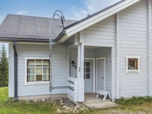A single-story house with a covered porch, a visible door, and a small window.