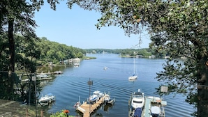 A marina with boats docked, surrounded by trees and a clear sky.