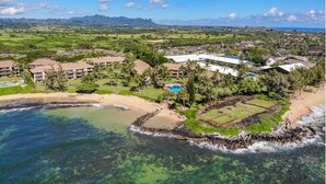 An aerial view of a resort with multiple buildings, a beach, and clear waters. - "Pacific Paradise" - Lae Nani 425 - Upgraded Second Floor 2 Bedroom | 2 Bathroom-with A/C (Kapaa)