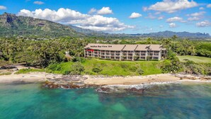 A hotel with a view of the ocean and mountains. - "Oceanfront Condo: Coconut Tree & Ocean Views, Whale Watching, Paddlers, and Surfers at Wailua Bay!" (Kapaa)