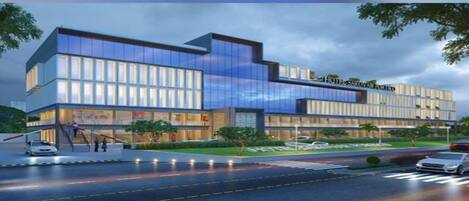 A modern hotel with a glass facade, multiple floors, and a prominent entrance with steps.