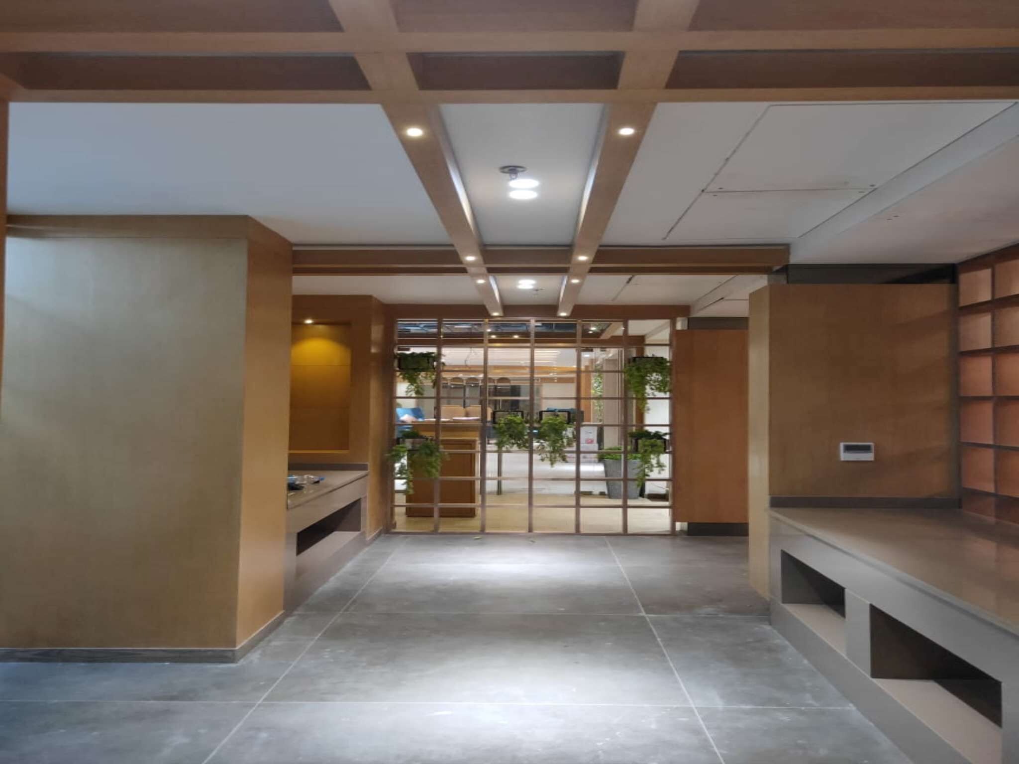 A modern interior with a tiled floor, wooden paneling, and a glass partition.
