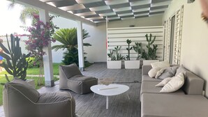 A modern outdoor seating area with a sofa, chairs, and a coffee table.