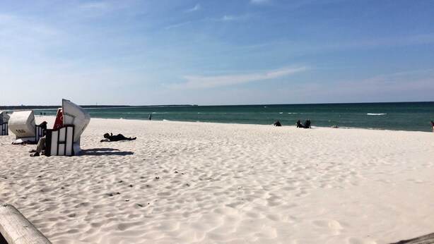Une plage de sable blanc, avec l’océan en toile de fond.