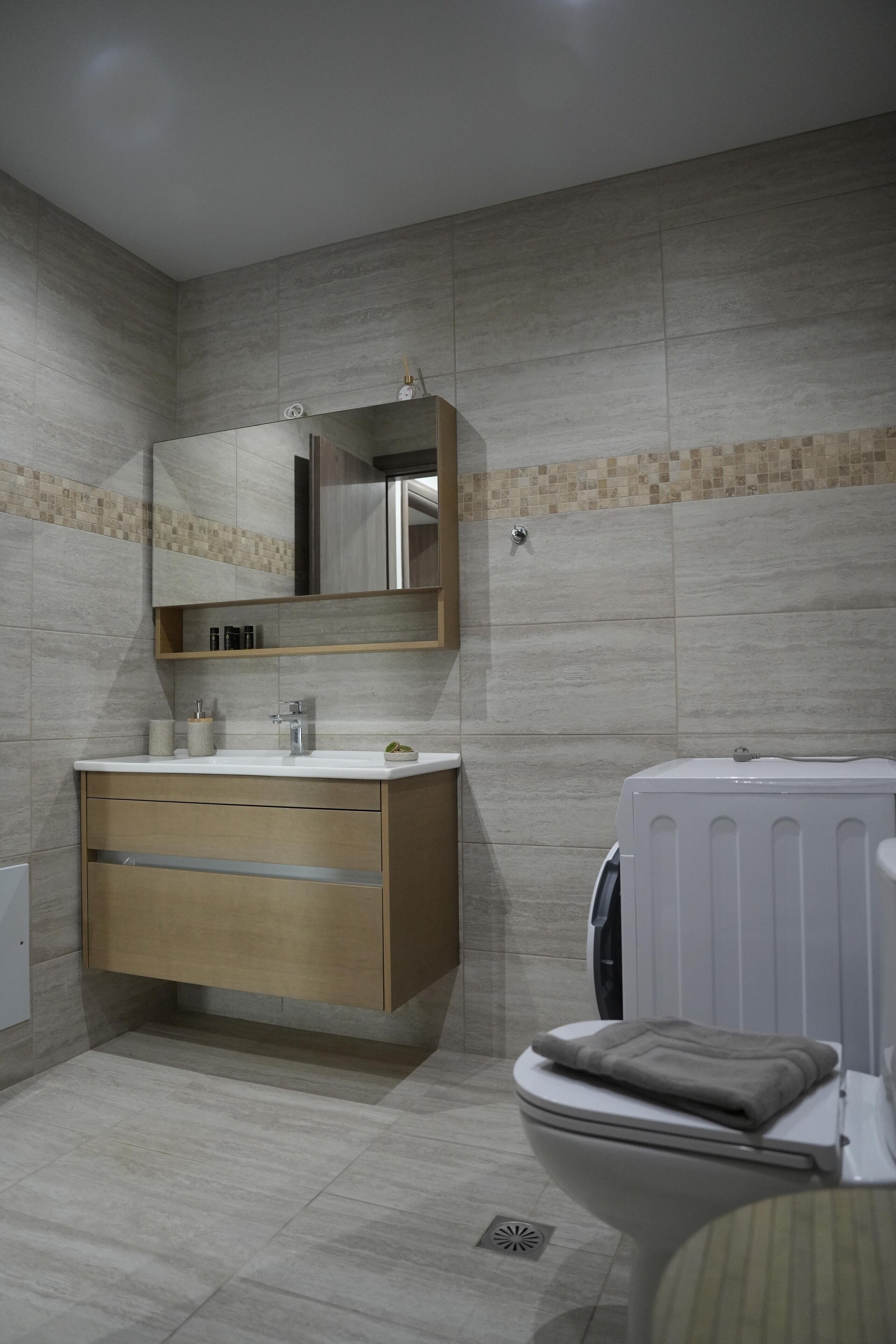 A bathroom with a toilet, a sink with a mirror, and a radiator.