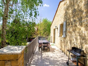 A stone building with a balcony, a table, and a grill. - Charming house near Domme and La Roque-Gageac (La Roque-Gageac)