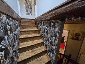 Un escalier en bois agrémenté d’un papier peint à motifs.
