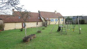 A grassy yard with a swing set, a ladder, and potted plants. - Charming Countryside Retreat with Fireplace, Garden, and Family Amenities in Tourtoirac, France (Tourtoirac)