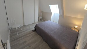A bedroom with a bed, a chair, a desk, and a window. - Charming house near Domme with Wifi, 2 bedrooms (Domme)