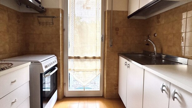 A compact kitchen with a stove, oven, sink, and white cabinets. - M282 - Marcelli, three-room apartment with garden 100m from the sea (Marcelli)