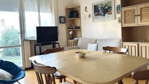 A dining area with a table, chairs, a television, a sofa, and a bookshelf. - M282 - Marcelli, three-room apartment with garden 100m from the sea (Marcelli)