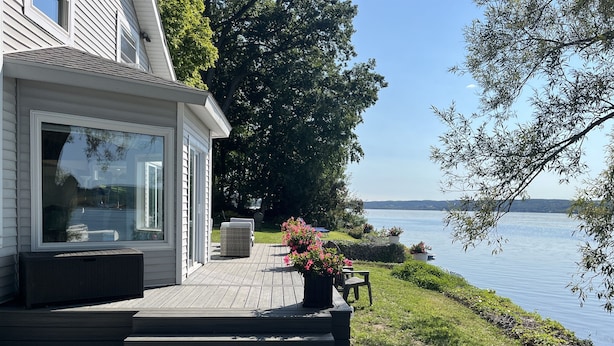 A waterfront patio with outdoor seating and a view of the lake.