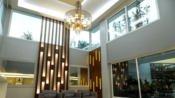 A modern interior with a reception area, large windows, and a chandelier. - Hotel Alvorada (Concordia)