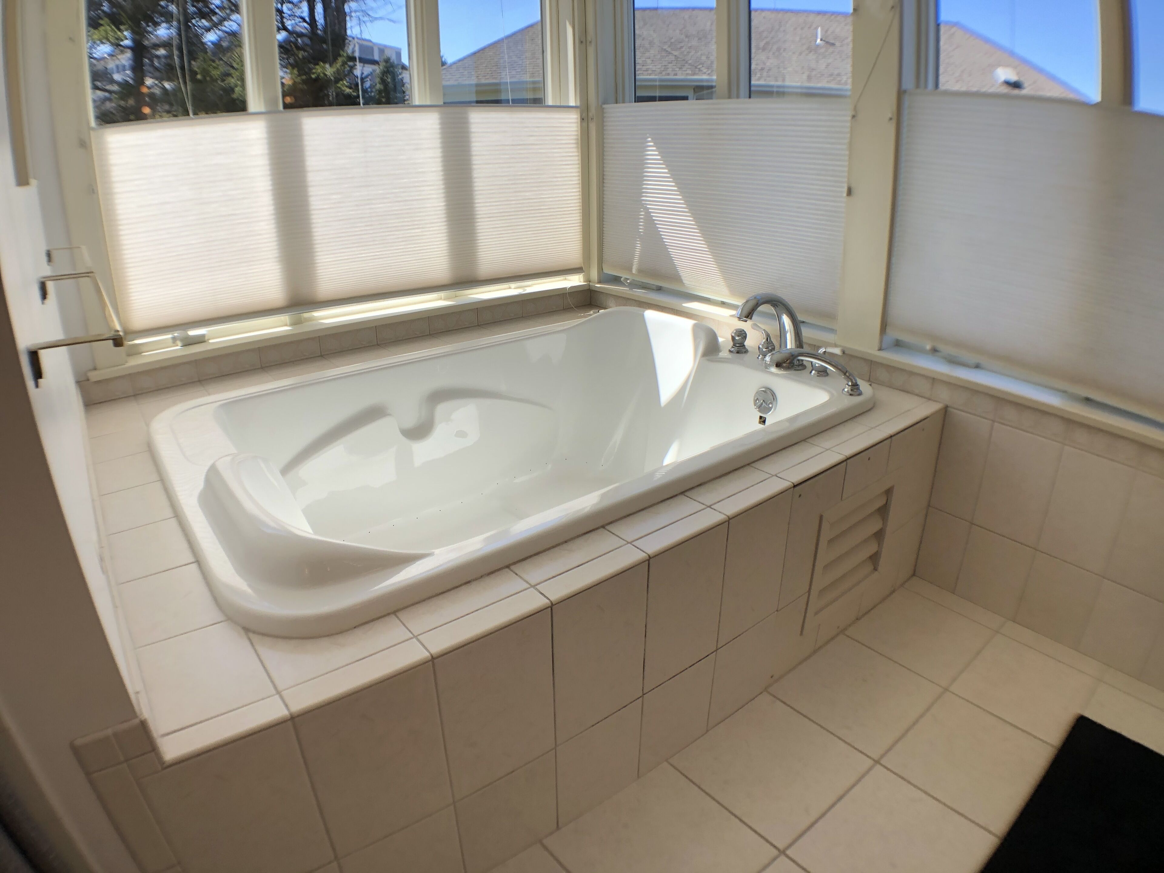Un baño moderno con una bañera grande, ducha y ventana que proporciona luz natural.