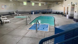 Et poolområde med flere pools, liggestole og gelændere.