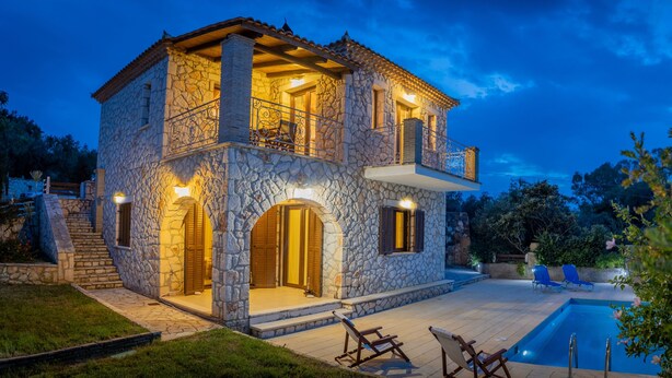 A stone villa with a pool, outdoor seating, and a staircase leading to the entrance. - Afrati villa (Zakynthos)
