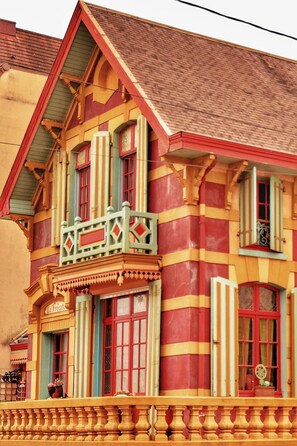 A colorful building with a balcony, large windows, and a sign that reads "La Petite."