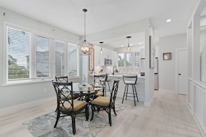 A modern kitchen with white cabinets, a central island, and pendant lighting.