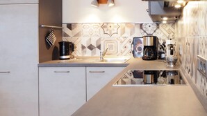 Una cocina moderna con una isla central, una cafetera y un hervidor.