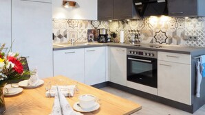 Una cocina moderna con una mesa de comedor de madera, una cafetera y un horno empotrado.
