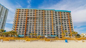 A multi-story hotel with balconies, located near a sandy beach. - Landmark 607 (Myrtle Beach)