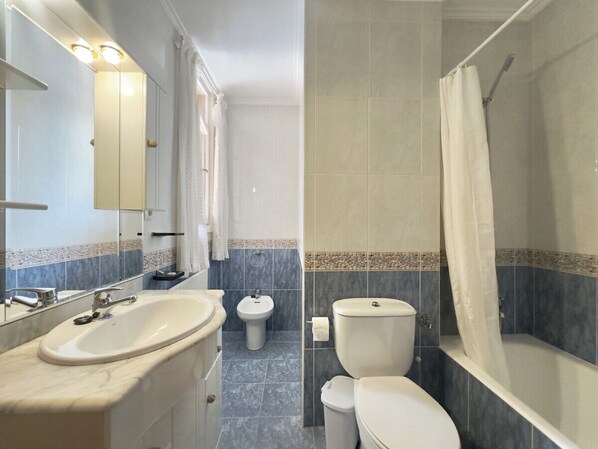 Un baño con lavamanos, bidé, inodoro y bañera.