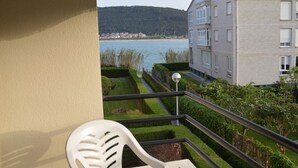 A balcony with a view of a body of water and a distant town.