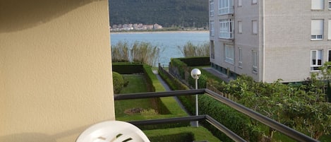 A balcony with a view of a body of water and a distant town.