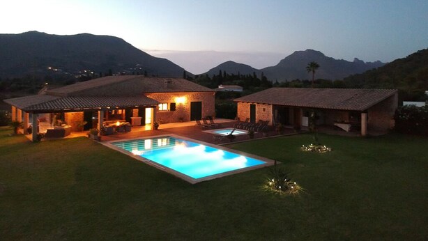 Une propriété résidentielle dotée d’une piscine, d’un espace extérieur aménagé et offrant une vue sur les montagnes.