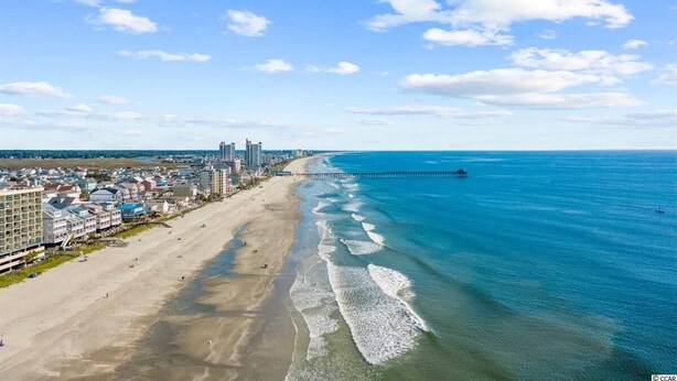A coastal cityscape with a beach, buildings, and a pier extending into the ocean. - 4 BR beach house 2 blocks from ocean in Cherry Grove! Dog friendly! (North Myrtle Beach)