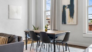 A dining area with a wooden table, six chairs, and a modern painting. - Downtown Cartersville 1BR Loft 1 (Cartersville)