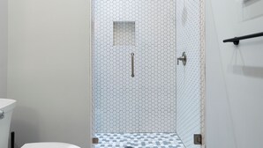 A modern bathroom with a shower, toilet, and sink. - Downtown Cartersville 1BR Loft 1 (Cartersville)
