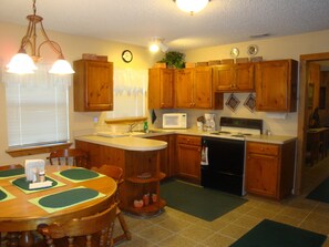 Enjoy cooking in this fully equipped kitchen with a central island, microwave, coffee maker, and stove.