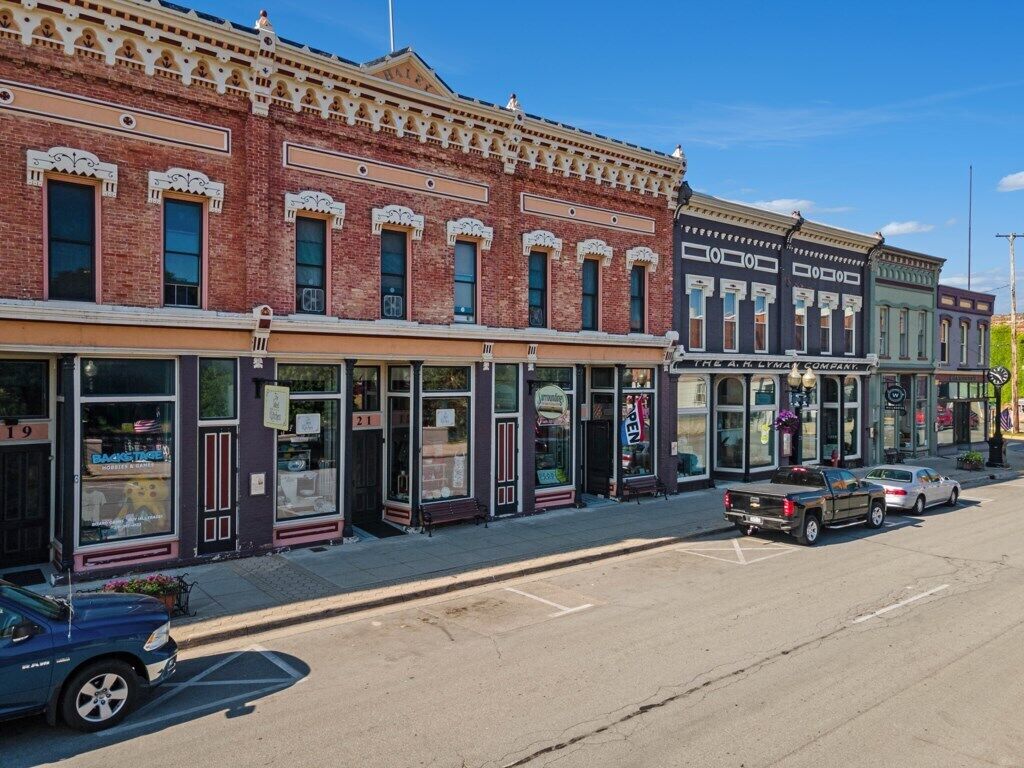 A row of historic buildings with storefronts, including a bank and a jewelry store.