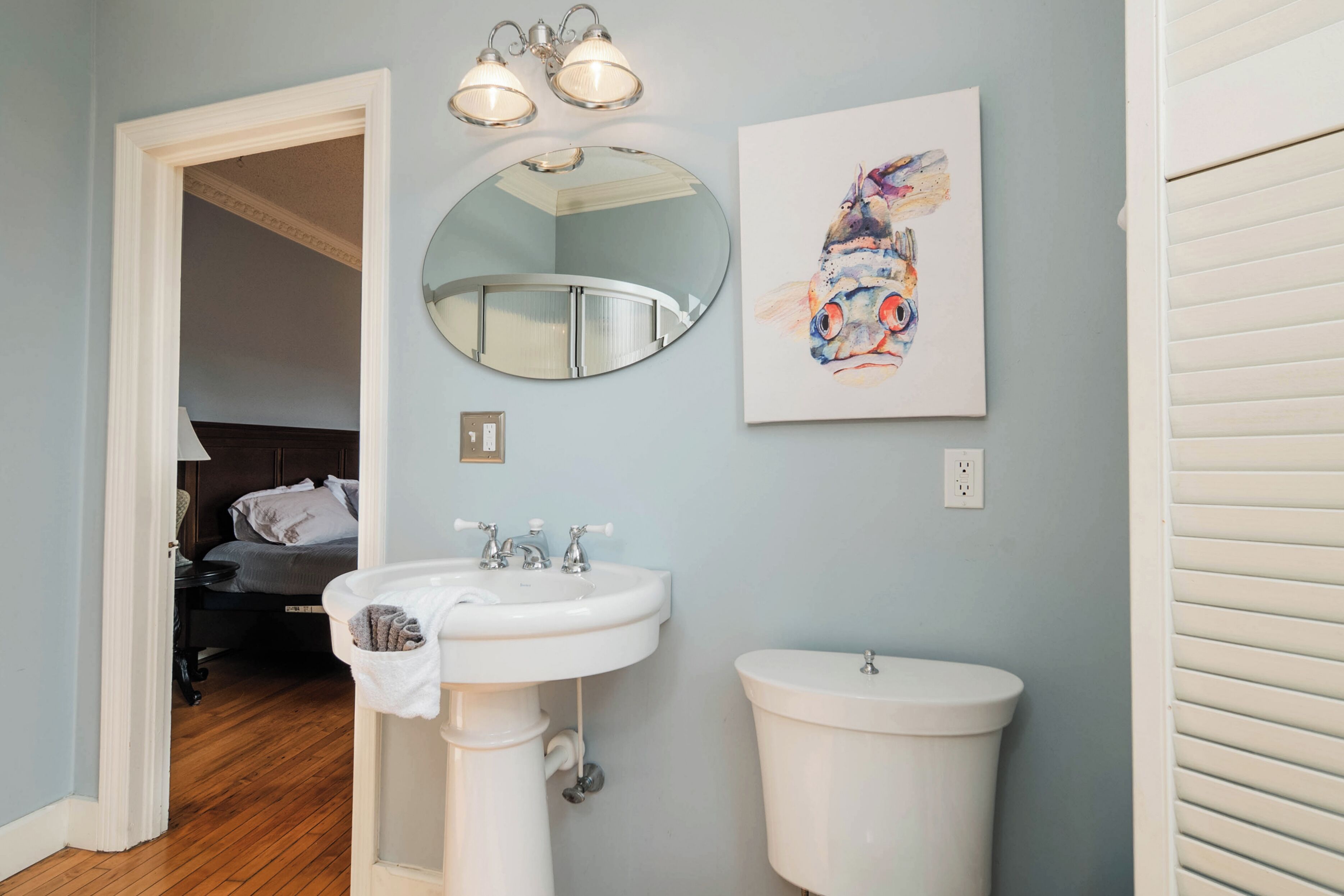 A bathroom with a sink, toilet, and a mirror.