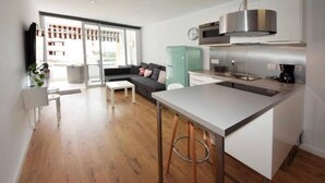 A modern kitchen with a central island, a built-in oven, and a stainless steel range hood.