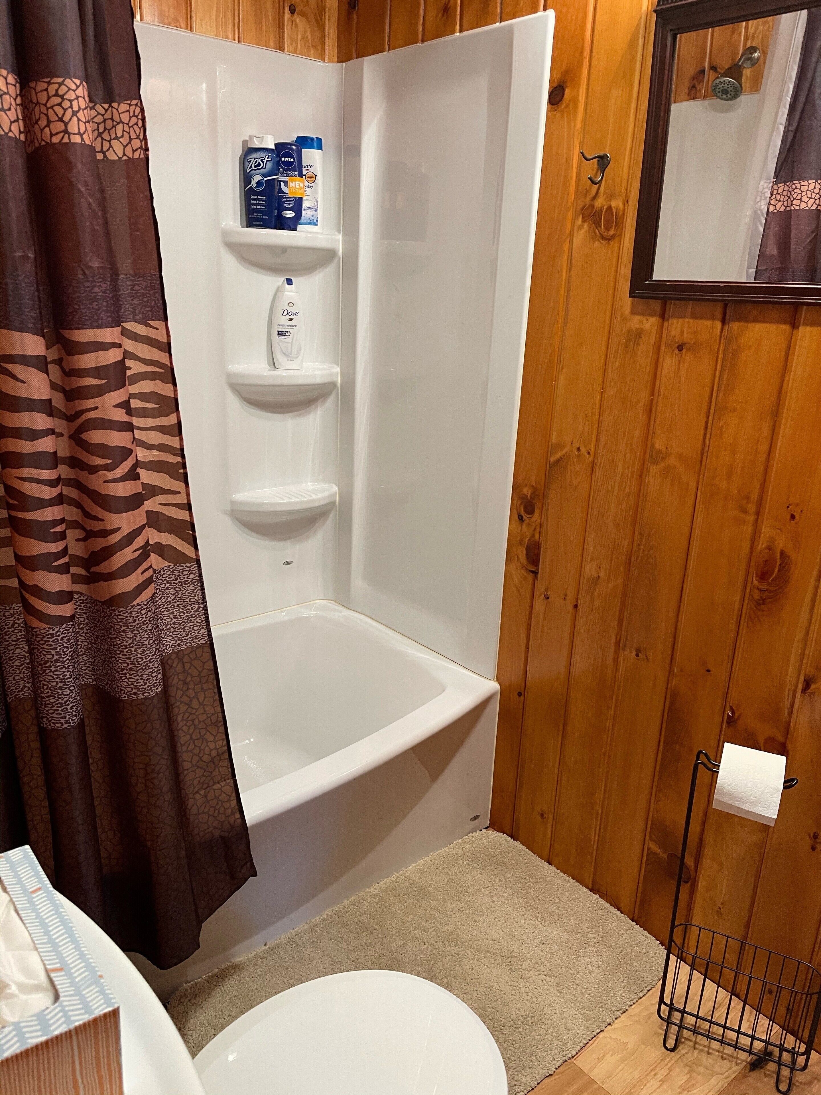 Un baño con bañera, inodoro y cortina de ducha.