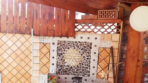A tiled outdoor kitchen area with a mosaic backsplash, wooden fence, and a small lantern. - House (Agropoli)