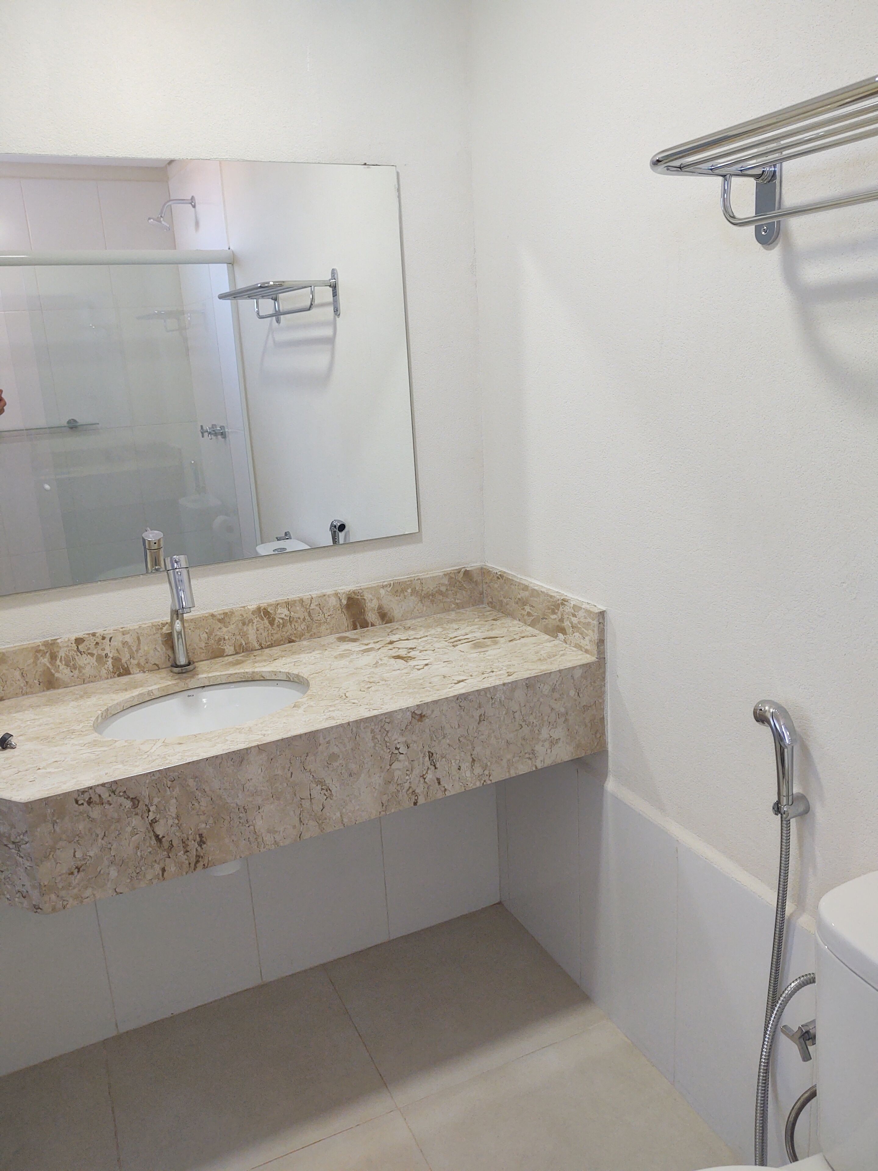 Un baño con lavamanos doble, espejo, ducha e inodoro.