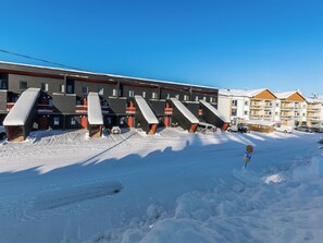 Een hotel met meerdere balkons en een met sneeuw bedekte grond.