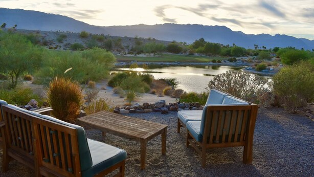 A patio with wooden furniture and a view of a lake and mountains. - Casa de Vistas~ 2bdr 2bath with a view! (Borrego Springs)