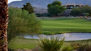A golf course with a desert landscape, a building with large windows, and a mountain in the background. - Casa de Vistas~ 2bdr 2bath with a view! (Borrego Springs)